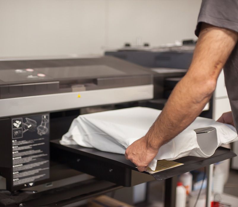 Mitarbeiter bei der Positionierung und Ausrichtung eines T-Shirt für den Druck